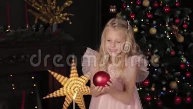 一个十岁的女孩靠近新年树，手里拿着一个新年玩具。 2020年新年。